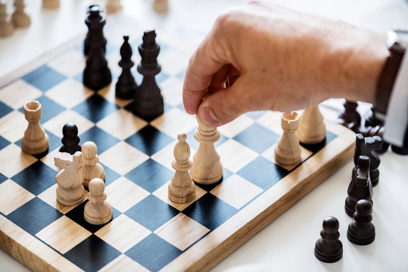 Older hand playing chess